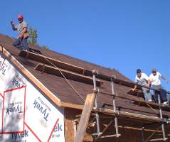 Homeowner waves from roof after installing the Genesis Safety System